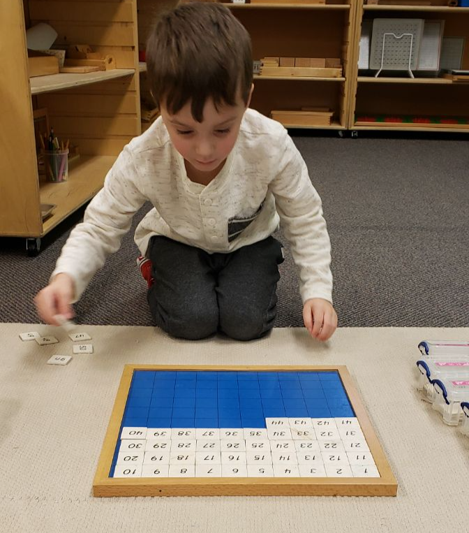 Primary boy working with 1 to 99 number puzzle